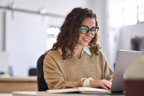 Female business owner writing a blog on laptop